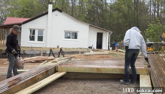 Applying penetrating wood sealer to decking boards before installation, ensuring long-term protection.