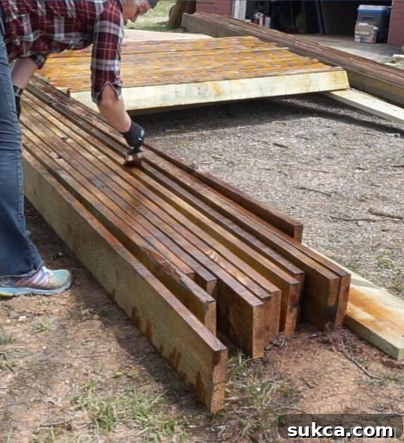 Close-up of a worker meticulously applying stain and sealer to individual deck boards.