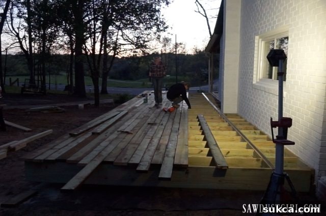 Panoramic view of the deck progressing, with a significant portion of the decking boards already installed.