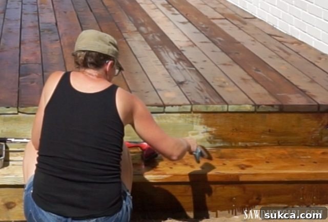 Applying stain and sealer to the newly built deck steps, ensuring protection and aesthetic consistency.