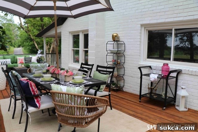 A beautifully furnished wood deck, set for outdoor dining and entertaining, overlooking scenic views.