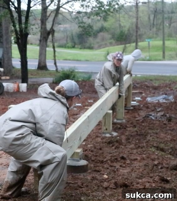 Two primary deck beams set in place, amidst challenging weather conditions, indicating a pause for reevaluation.