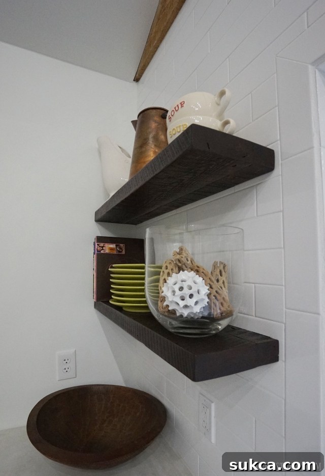 Vertical view of kitchen with reclaimed lumber floating shelves and modern fixtures