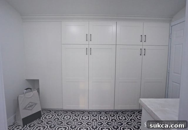Custom-built broom cabinet integrated with IKEA cabinets in the laundry room