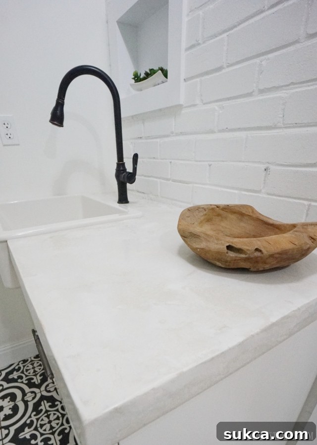 Detail of concrete countertop and farmhouse sink in the sophisticated laundry room