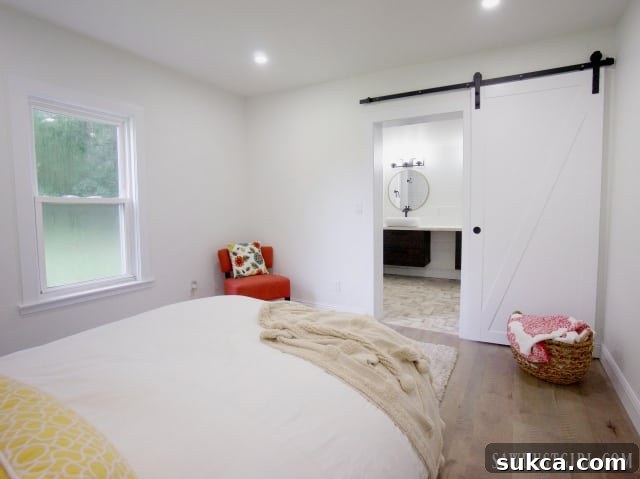 Master bedroom featuring a stylish white barn door and modern decor