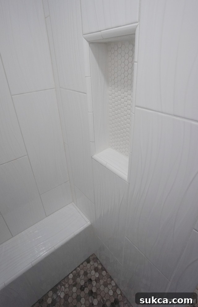 Detail of walk-in shower featuring a built-in bench and recessed niche