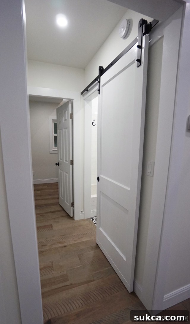 Close-up of a stylish white barn door with sleek black hardware
