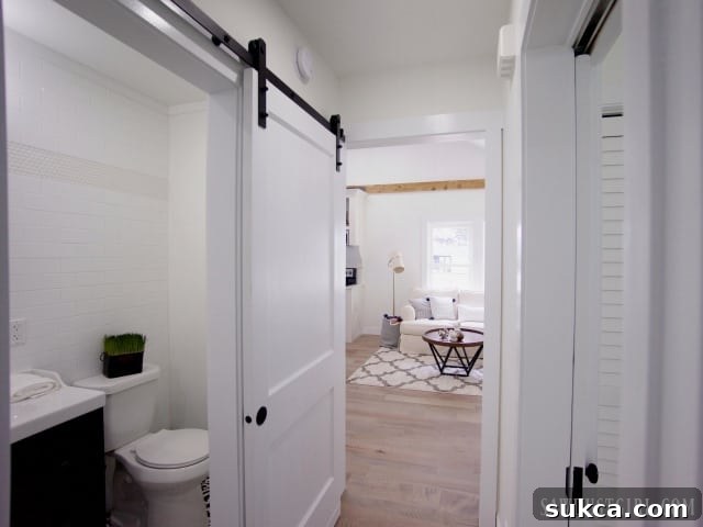 View of the hallway and a peek into the guest bathroom with its elegant barn door