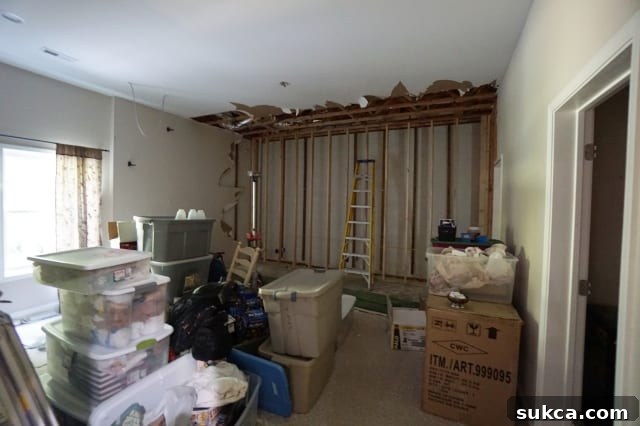 Messy basement bedroom with exposed studs and construction materials, reflecting the impact of a sewer issue