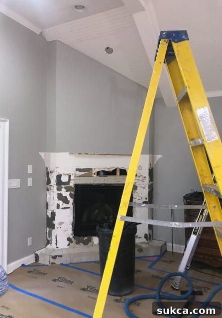 Demolition of an old fireplace mantel and tile, marking the start of a fireplace remodel
