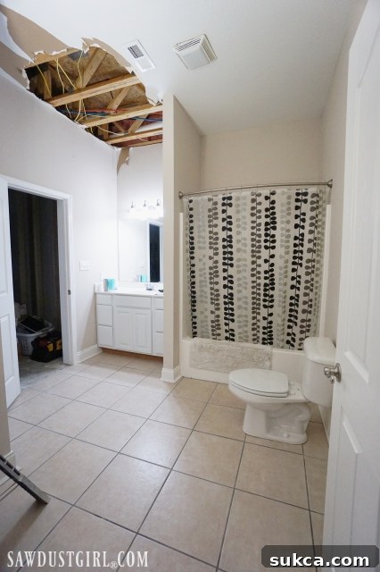 Before bathroom renovation showing visible ceiling guts and bland decor