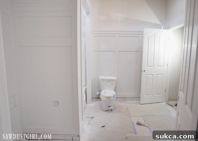 Spraying semi-gloss paint on the wainscoting and baseboards
