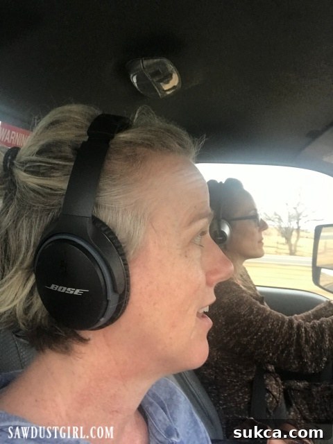 A person wearing headphones and a baseball cap is seen inside the noisy truck cab, looking weary from the long drive.