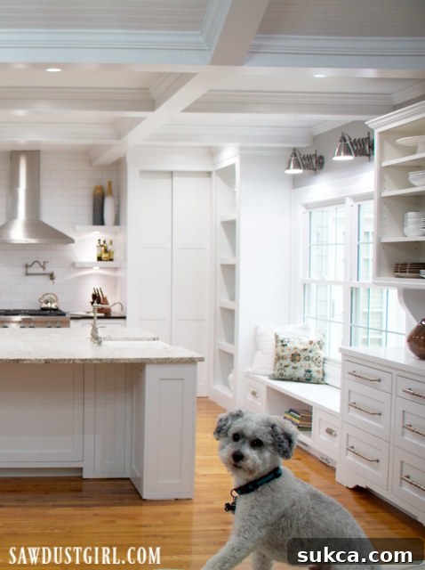Bright kitchen with white cabinets and pristine white granite countertops.