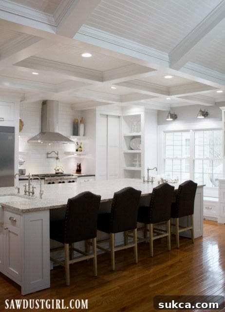 Elegant box beam ceiling in a pristine white kitchen, adding architectural interest.