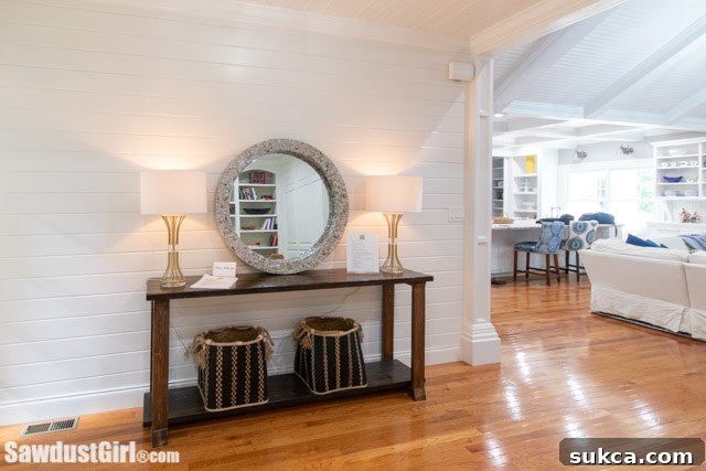 Custom built console table in a hallway adorned with elegant shiplap paneling, adding character and charm