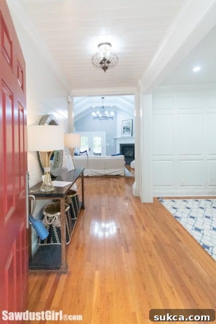 Welcoming red front door leading into a beautifully renovated home entryway.