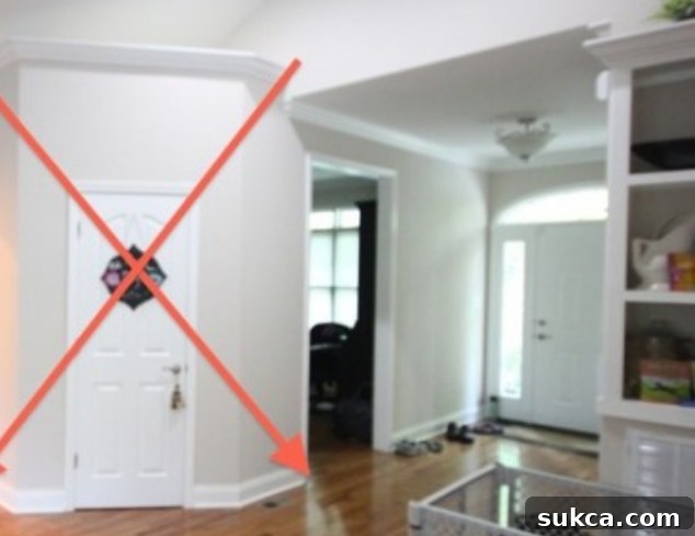 Before photo of a narrow, closed-off entry hallway leading into a small room, highlighting the original restrictive layout.