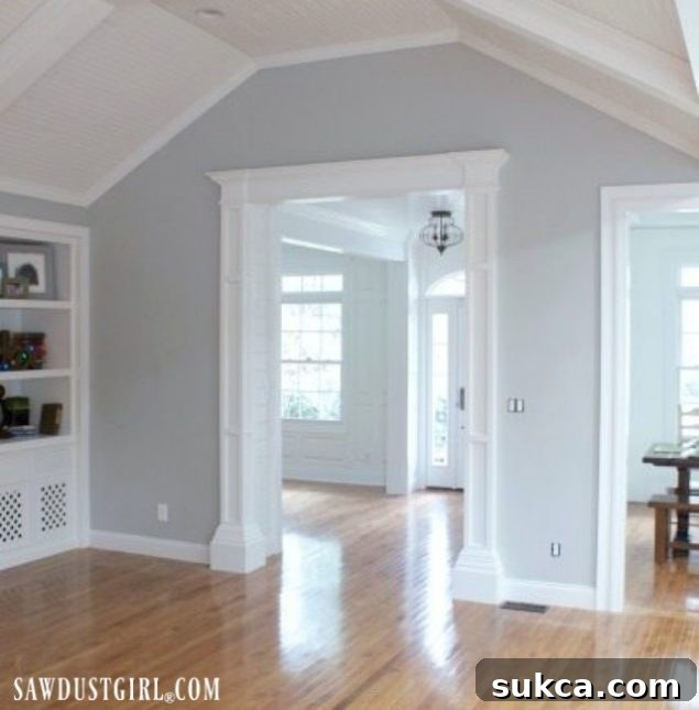 Renovated entry hallway looking towards the living room, featuring V-Groove plank ceiling, bulky doorway trim, and an open layout.