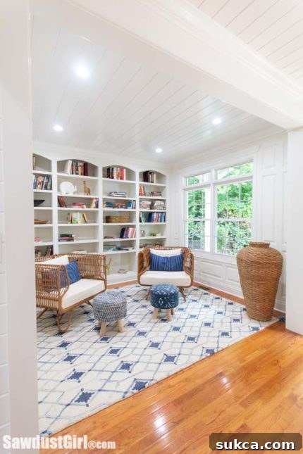 Luxurious library interior with planked ceiling, wainscoting, and a wall of arched built-in bookcases filled with books.