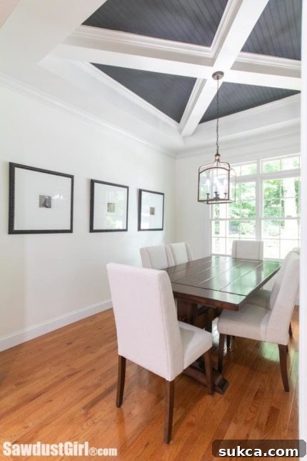 Dining room featuring unique X-beam coffered ceiling and open doorway to main living area.