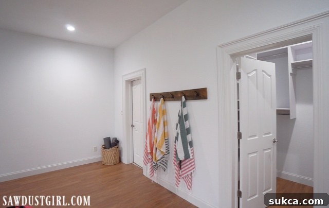 Reclaimed lumber towel rack installed in the renovated basement bedroom