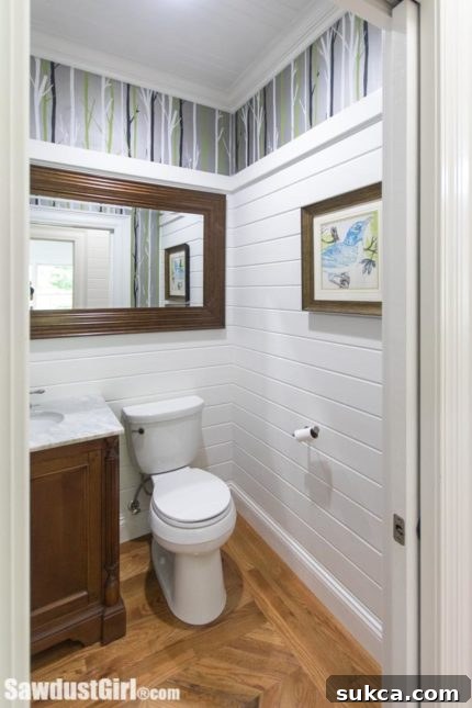 Elegantly designed powder room with unique wallpaper and fixtures.