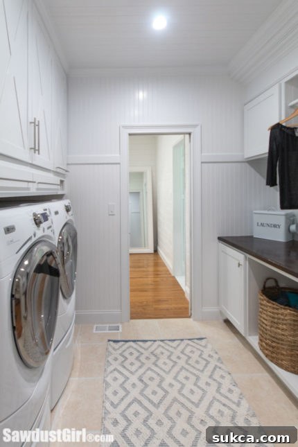 Organized laundry room with folding counter and deep cabinets