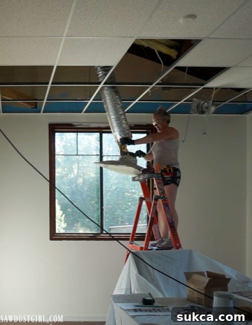 The process of removing old, large drop ceiling air vents to prepare for a modern ceiling upgrade.