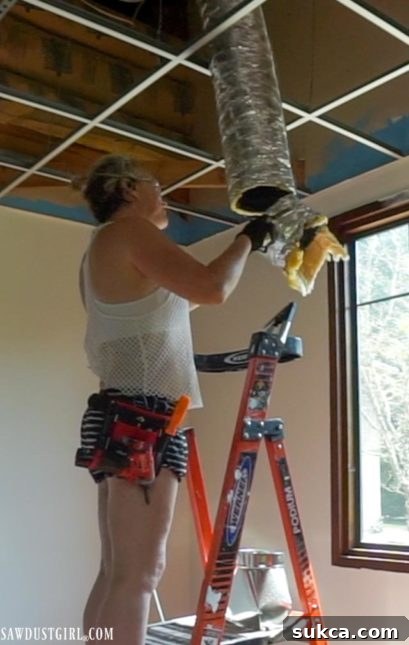 Detailed image of connecting flexible ducting to a new vent boot for ceiling installation.