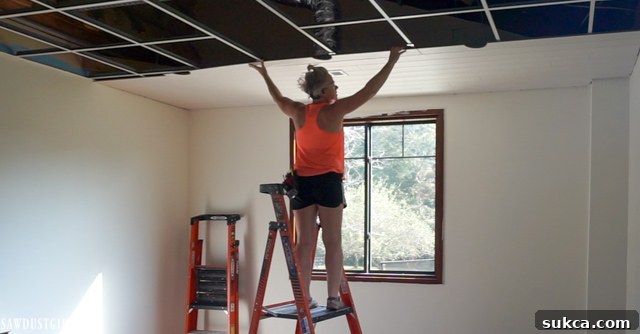 A jig saw being used to cut precise holes for recessed lighting in a WoodHaven ceiling plank before installation.