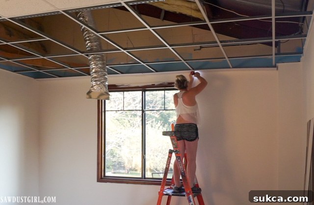 Detailed view of installing surface mount planks directly onto a drop ceiling grid, highlighting precision and technique.