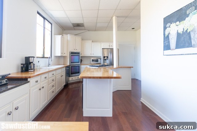 Dark to White Kitchen Transformation Updating a kitchen by painting its formerly dark brown cabinets and walls a pristine white, creating a dramatically improved and cohesive aesthetic.