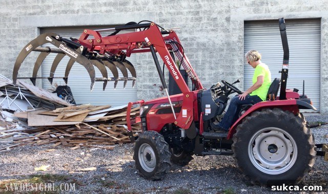 Tractor with Grappling Tool Tractor equipped with a grappling attachment, useful for clearing and moving heavy debris.
