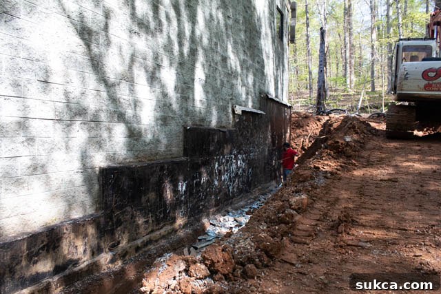 Foundation Waterproofing Application Applying waterproofing membrane to the foundation wall