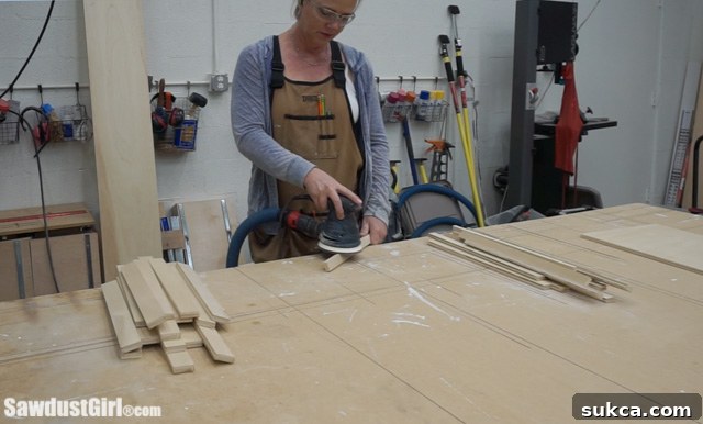 Sanding plywood edges before drawer assembly for a cleaner finish.