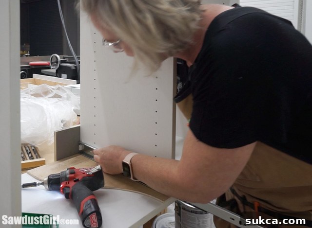 Testing drawer installation in the first cabinet, including shelf pin holes.