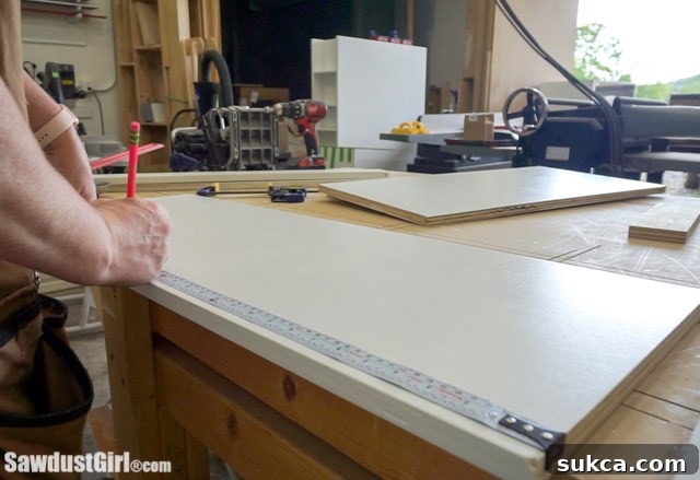 Marking center divider location on cabinet panels.