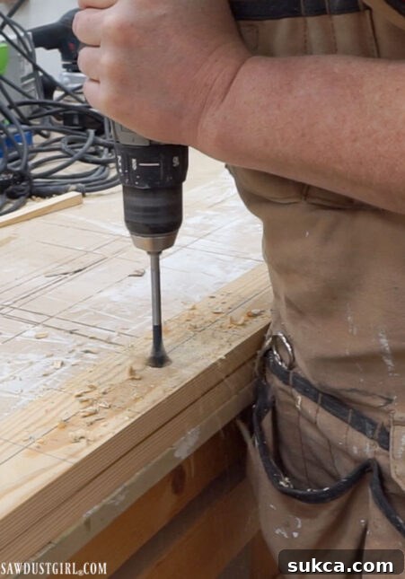 Drilling holes through both ladder legs simultaneously for perfect alignment