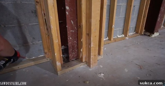 Sealing Wall Gaps with Foam Applying expanding foam sealant to a structural gap in a workshop wall, demonstrating air sealing techniques.
