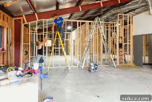 The team installing studs for an angled upper wall, requiring precise cuts