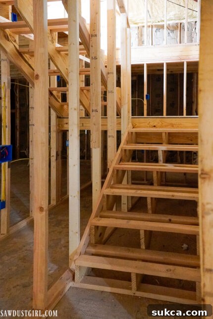 View of the loft subfloor laid, with temporary stairs providing access, demonstrating significant progress in the upper level of this DIY home improvement.