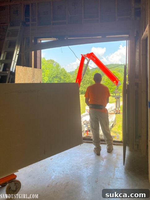 Lodge Drywall Installation Update 5 8 Crane delivering drywall sheets through the large temporary opening
