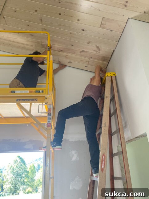 The final pine plank being installed in a newly whitewashed ceiling