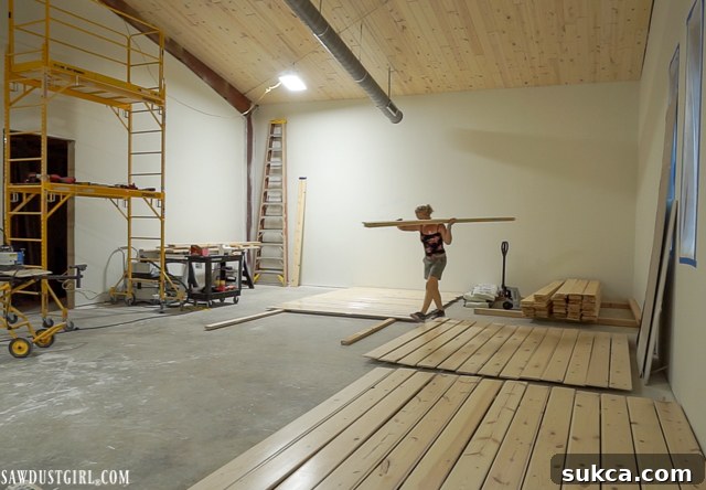 Pine planks laid out in a workspace to dry after being whitewashed for ceiling installation