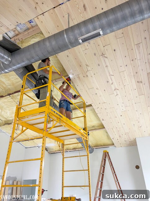 Installation of whitewashed pine ceiling planks in a lodge