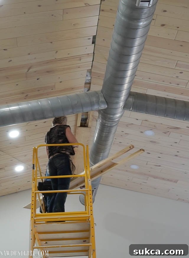 Large DIY faux wood beam installed on a white-washed ceiling, showing its rustic texture.