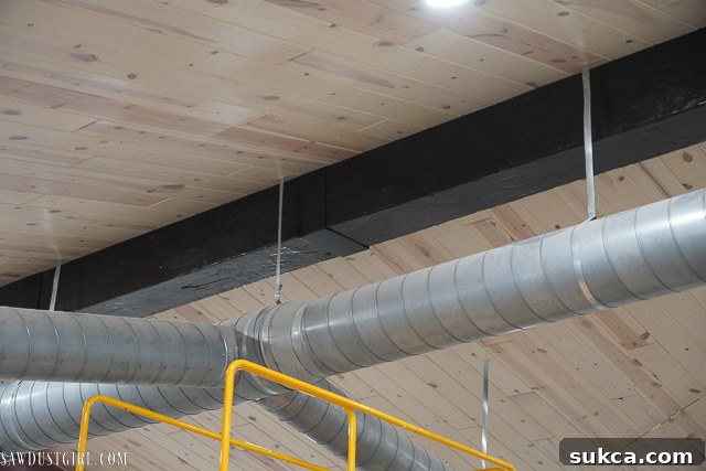 A close-up of a faux metal bracket made from plywood, covering a seam on the beam.