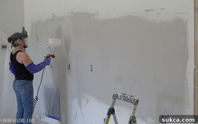 Concrete overlay being sprayed onto the wall with a hopper gun